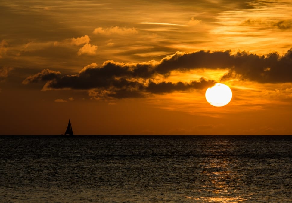 silhouette of sailboat on body of water during sunset preview