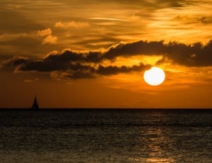 silhouette of sailboat on body of water during sunset thumbnail