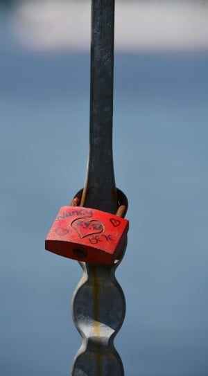 red padlock on gray metal fence thumbnail