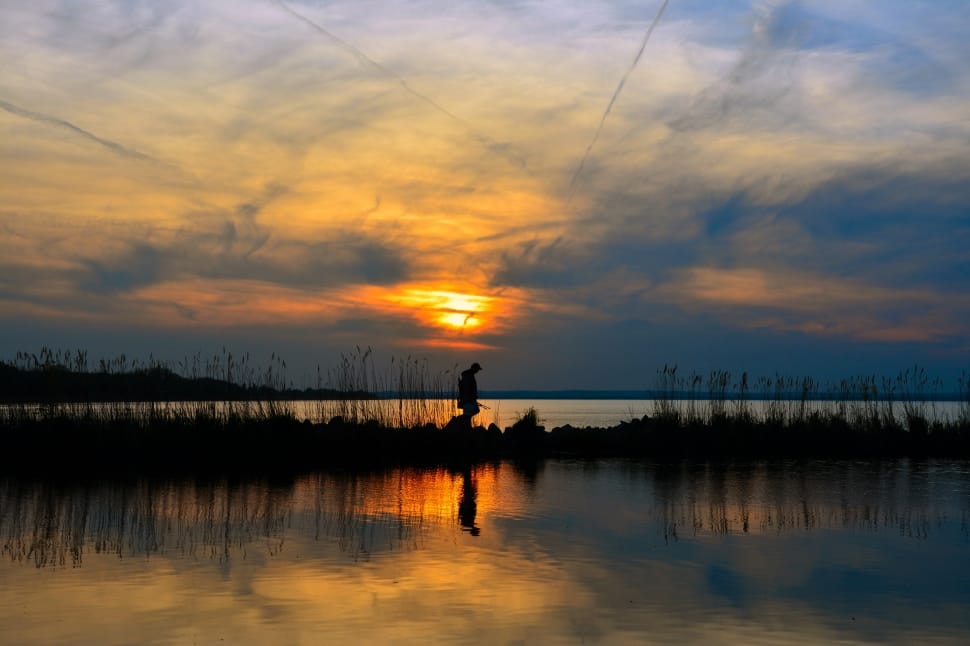 silhouette photo of man near river preview