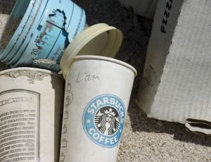 white and blue Starbucks Coffee plastic cup beside blue plastic bucket thumbnail