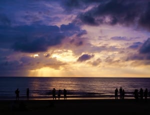 silhouette photo of people on beach on sunset thumbnail