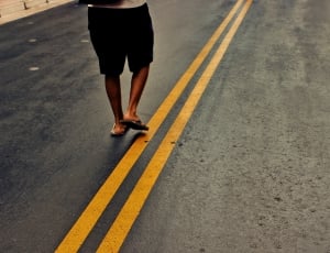 person standing on gray top road thumbnail
