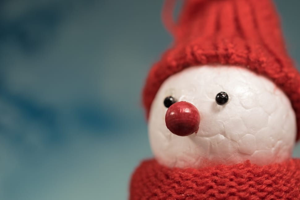 selective blurry photography of white and red crochet snowman toy preview