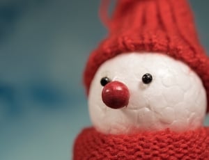selective blurry photography of white and red crochet snowman toy thumbnail