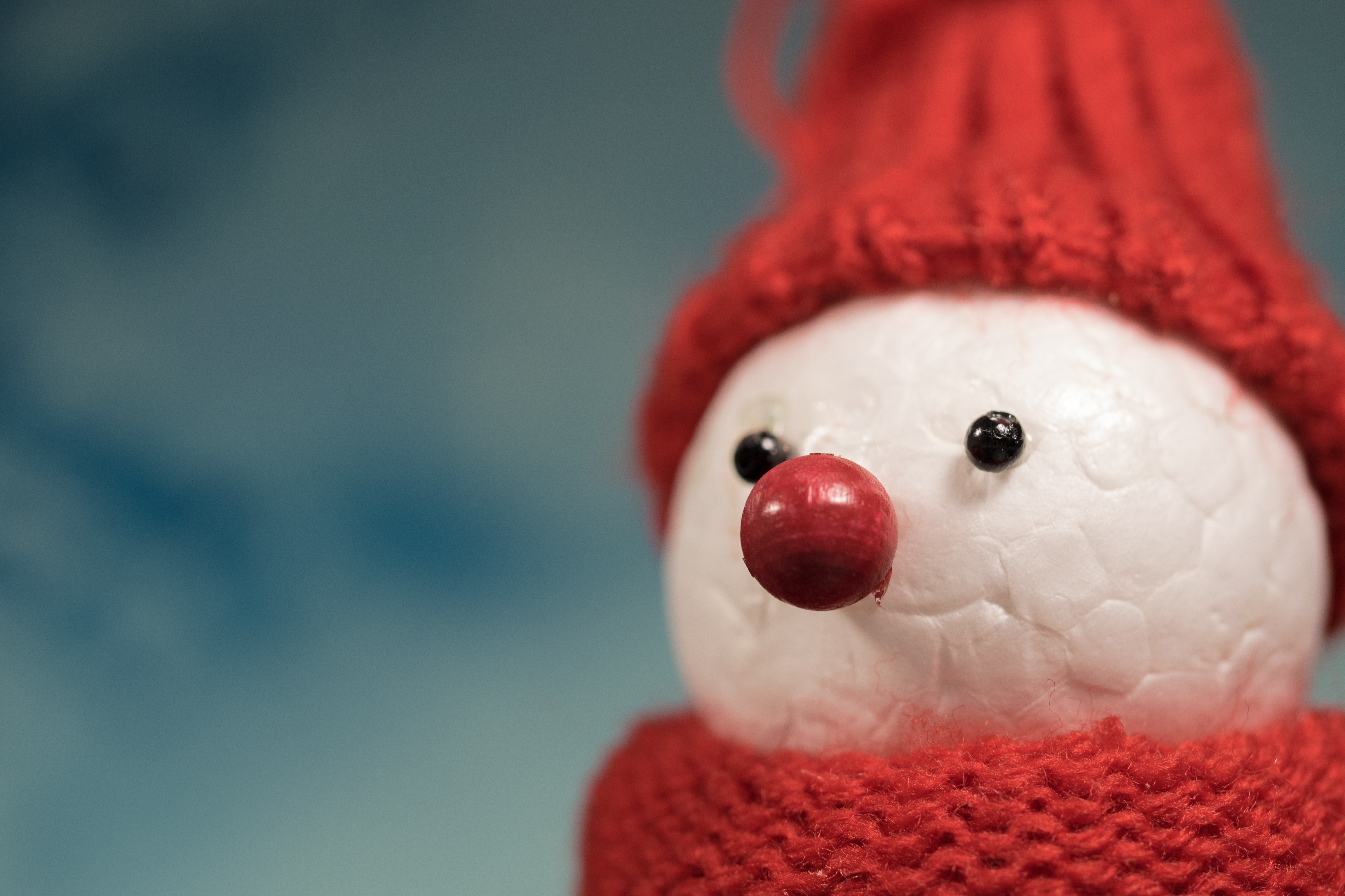 selective blurry photography of white and red crochet snowman toy