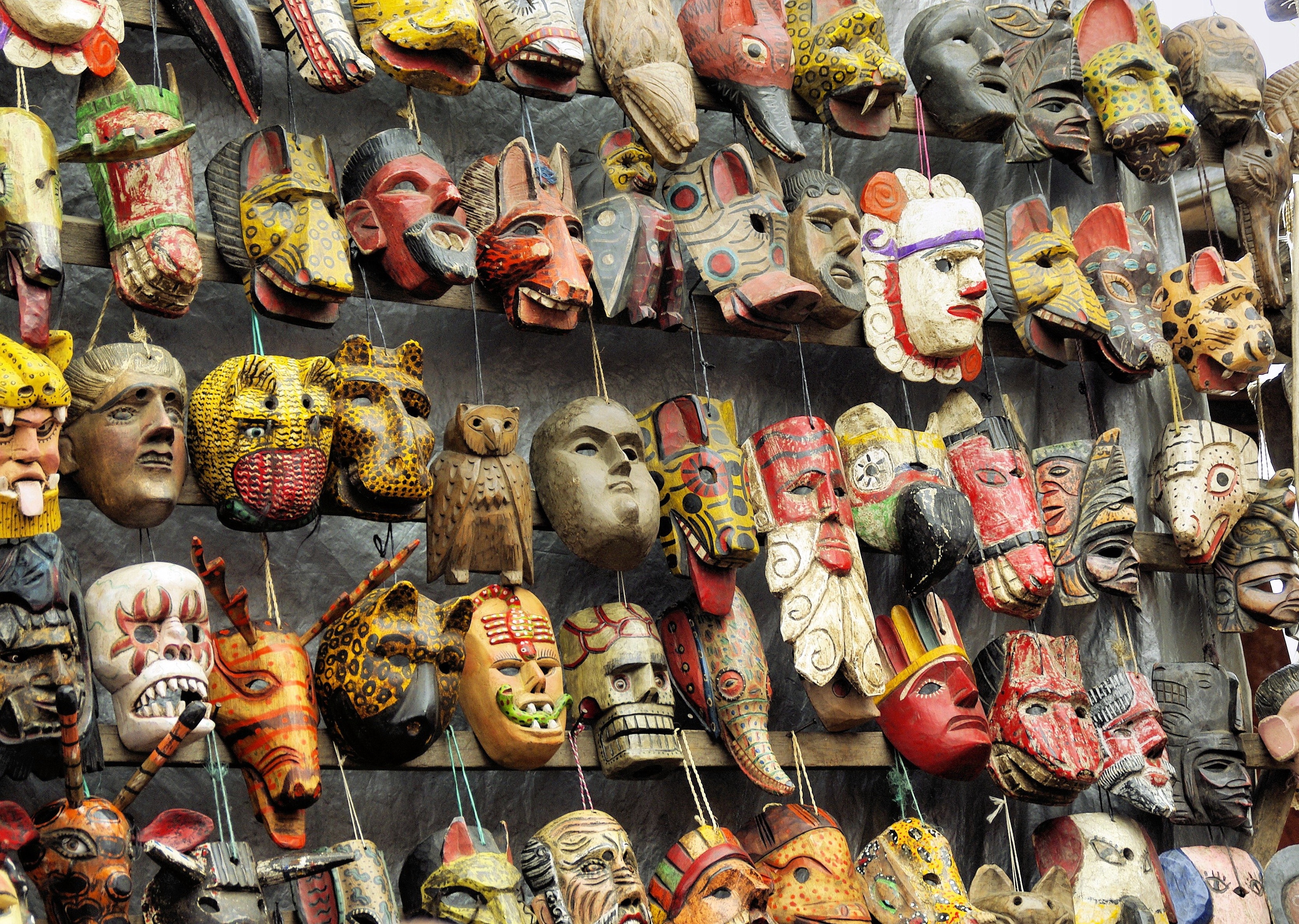 person takes picture of native masks