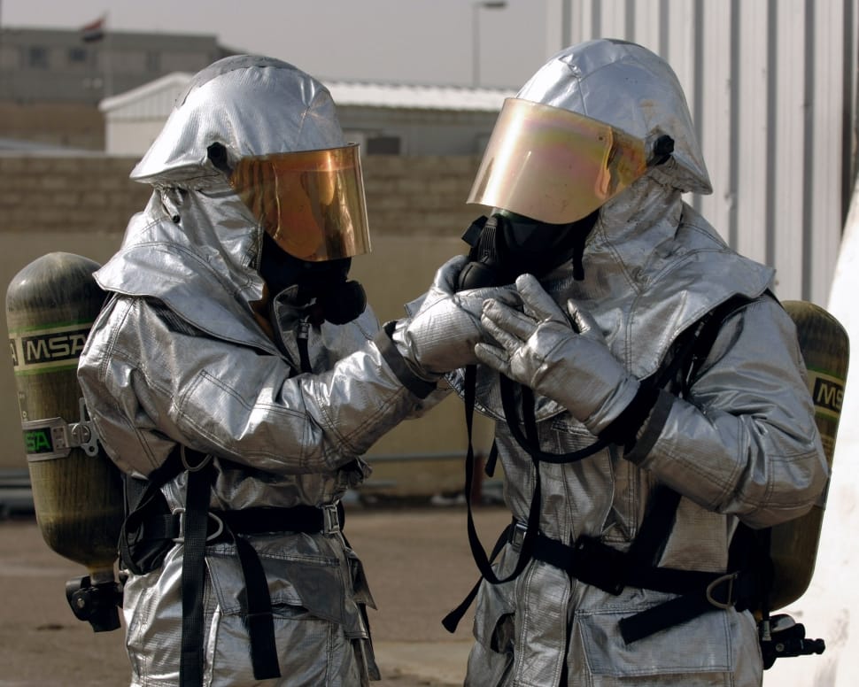 man wearing hazmat suit holding man's mask preview