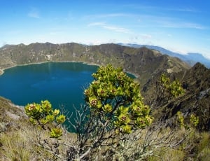 green mountains covering body of water during day time thumbnail