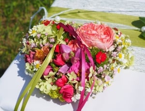bunch of yellow, pink and red flowers on a white textile thumbnail