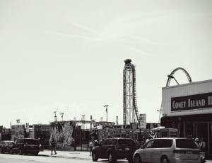 vintage grayscale photo of cars parked beside coney island building thumbnail