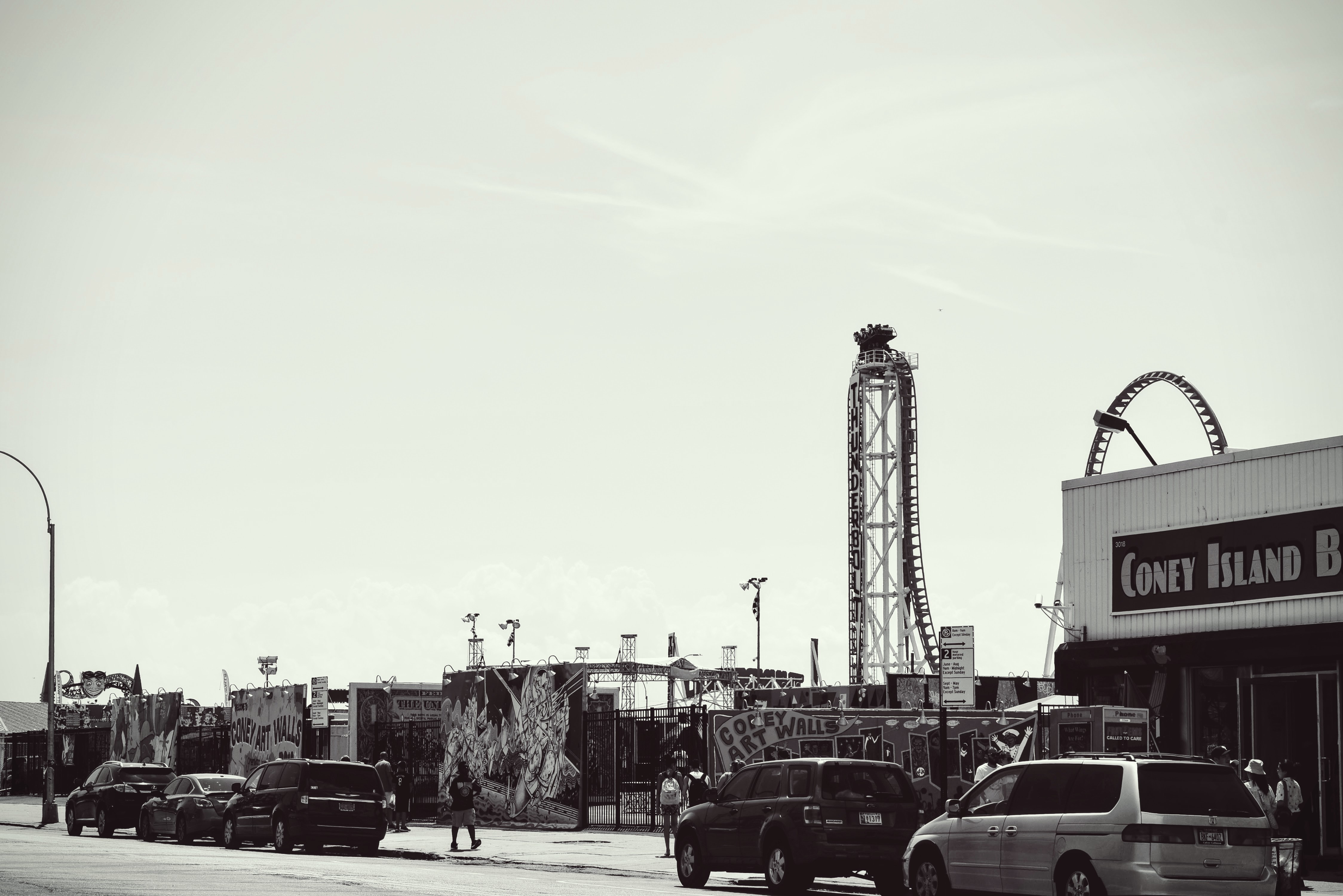 vintage grayscale photo of cars parked beside coney island building