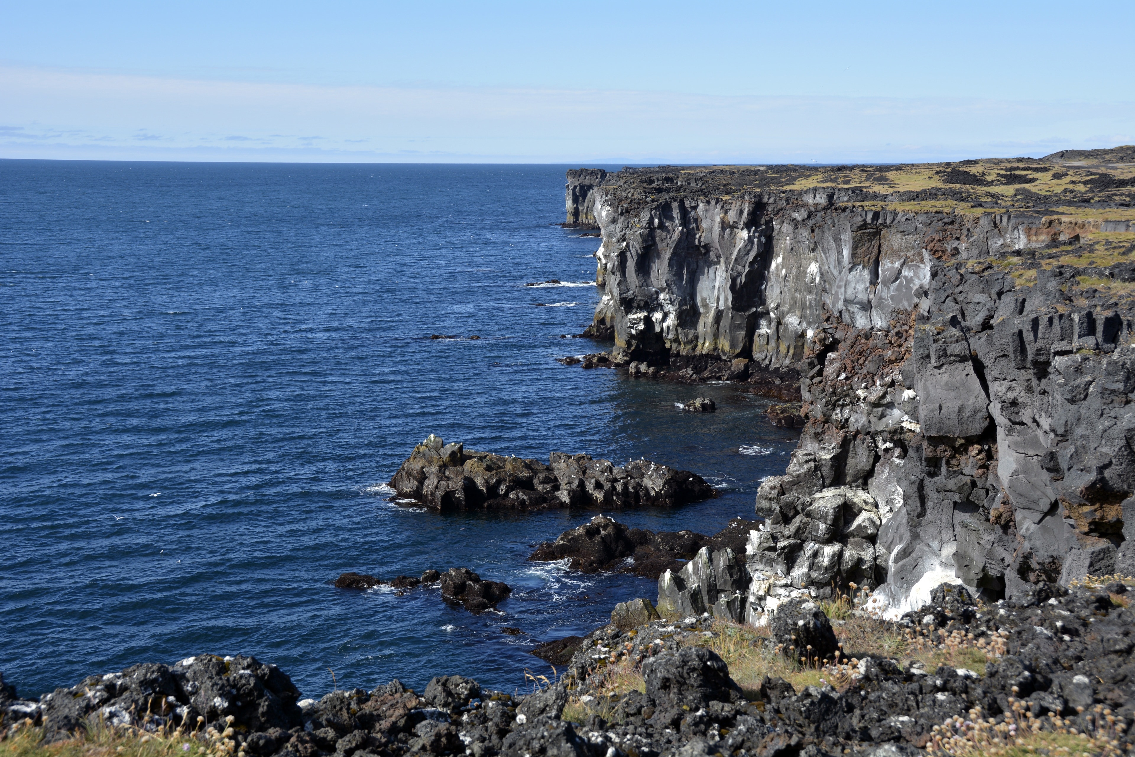 rocky cliff beside sea