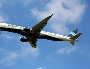 Azul commercial airplane flying under blue and cloudy sky during daytime thumbnail
