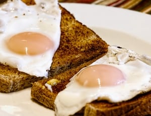 bread with egg on white round plates thumbnail