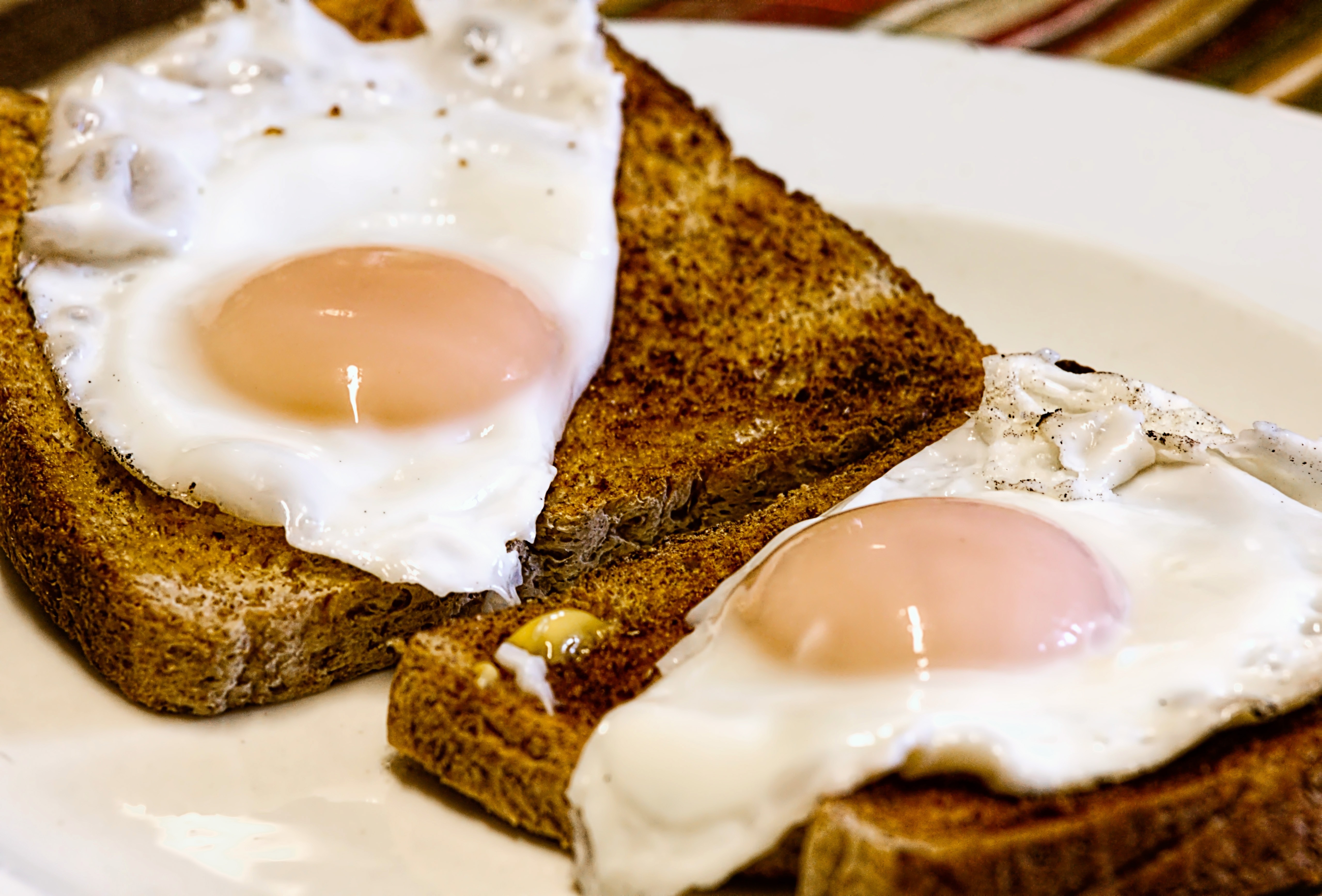 bread with egg on white round plates