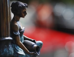 woman in blue dress holding brown vase figurine thumbnail
