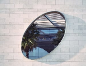stainless steel frame oval shape mirror on white surface thumbnail