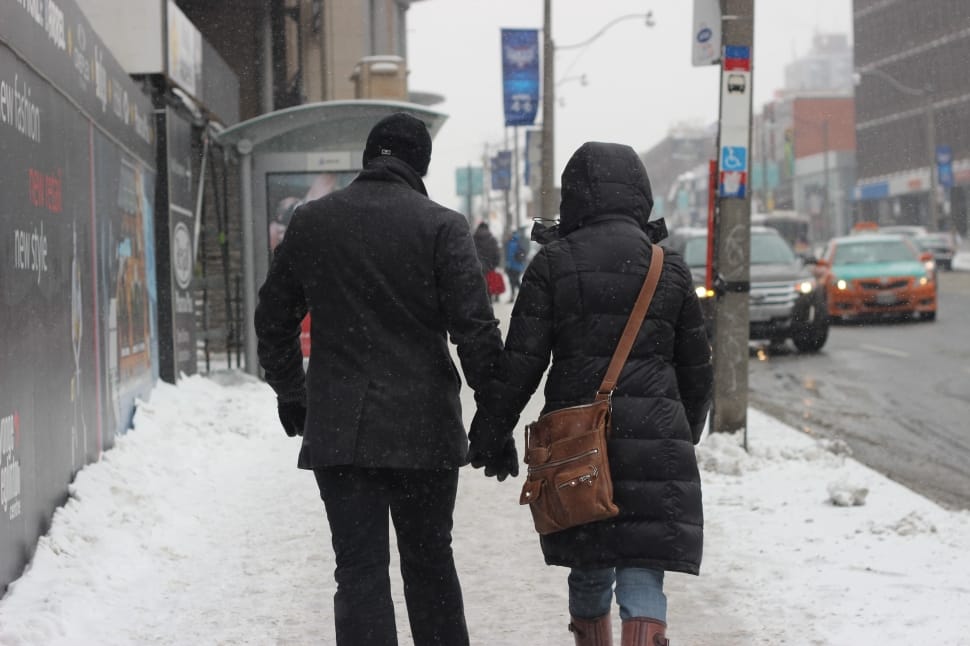 man and woman in jacket holding hands preview