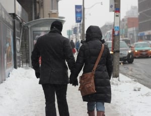 man and woman in jacket holding hands thumbnail