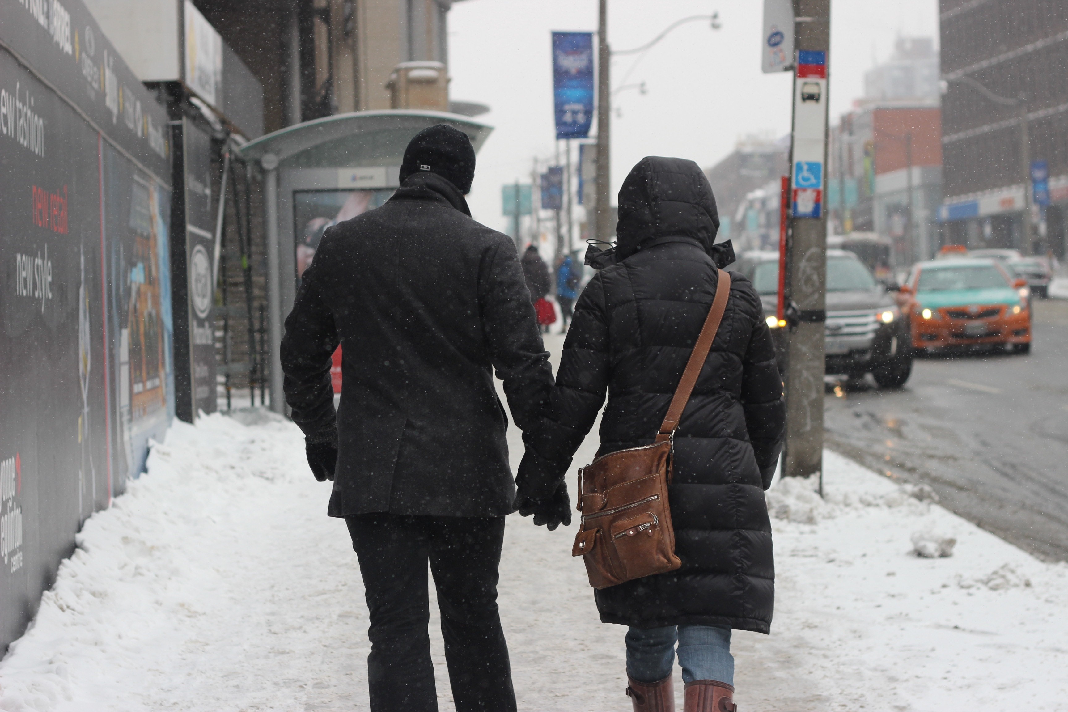 man and woman in jacket holding hands