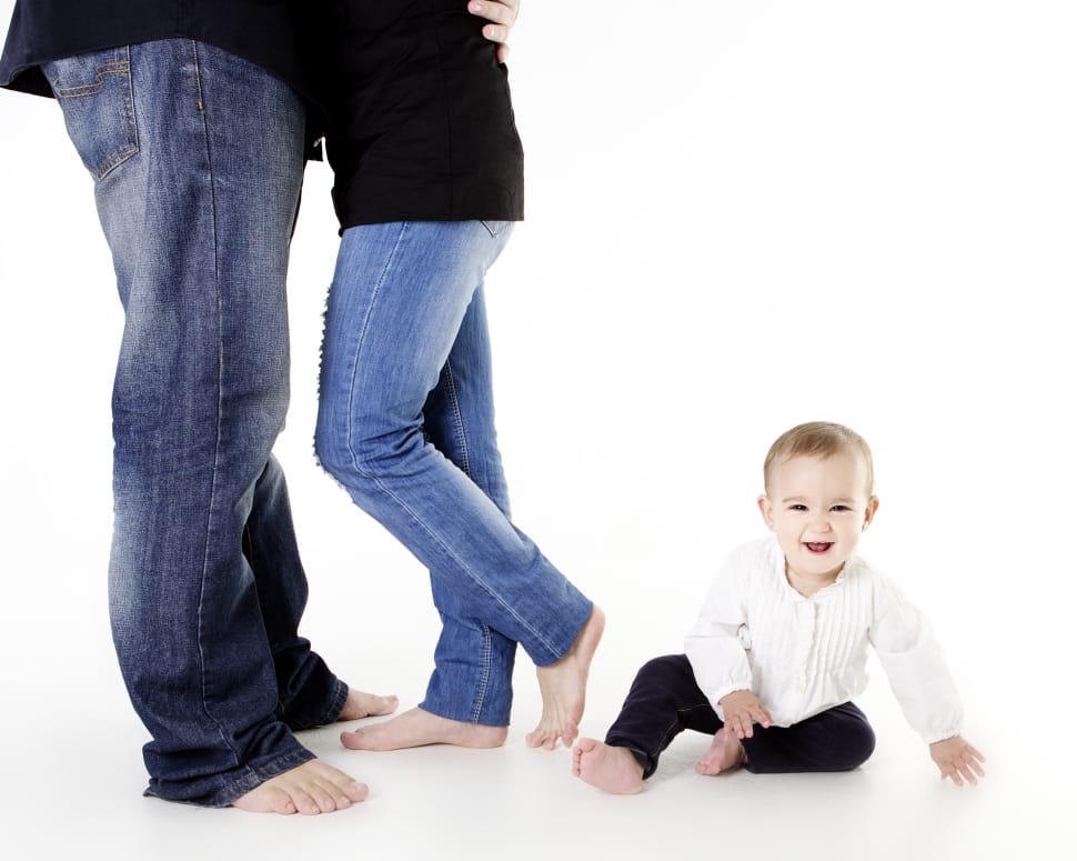 toddler lying on floor near couple standing preview