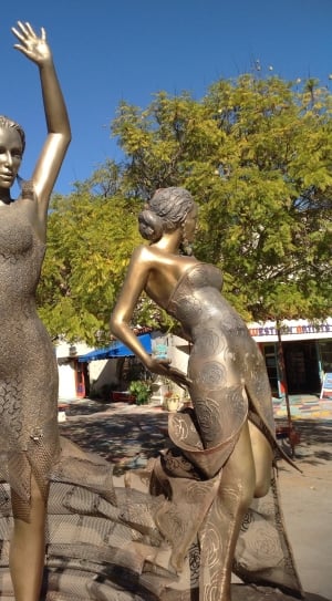 two brass woman statues on daylight thumbnail