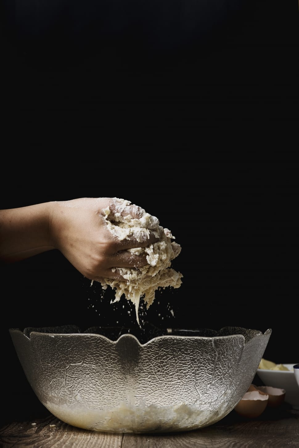 person holding white wet dough on clear glass bowl preview