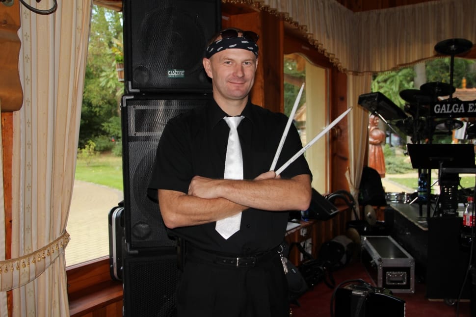 man in black polo shirt holding drumsticks preview