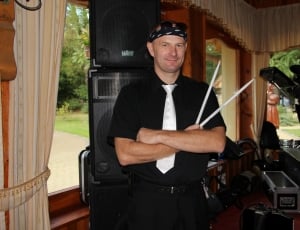 man in black polo shirt holding drumsticks thumbnail