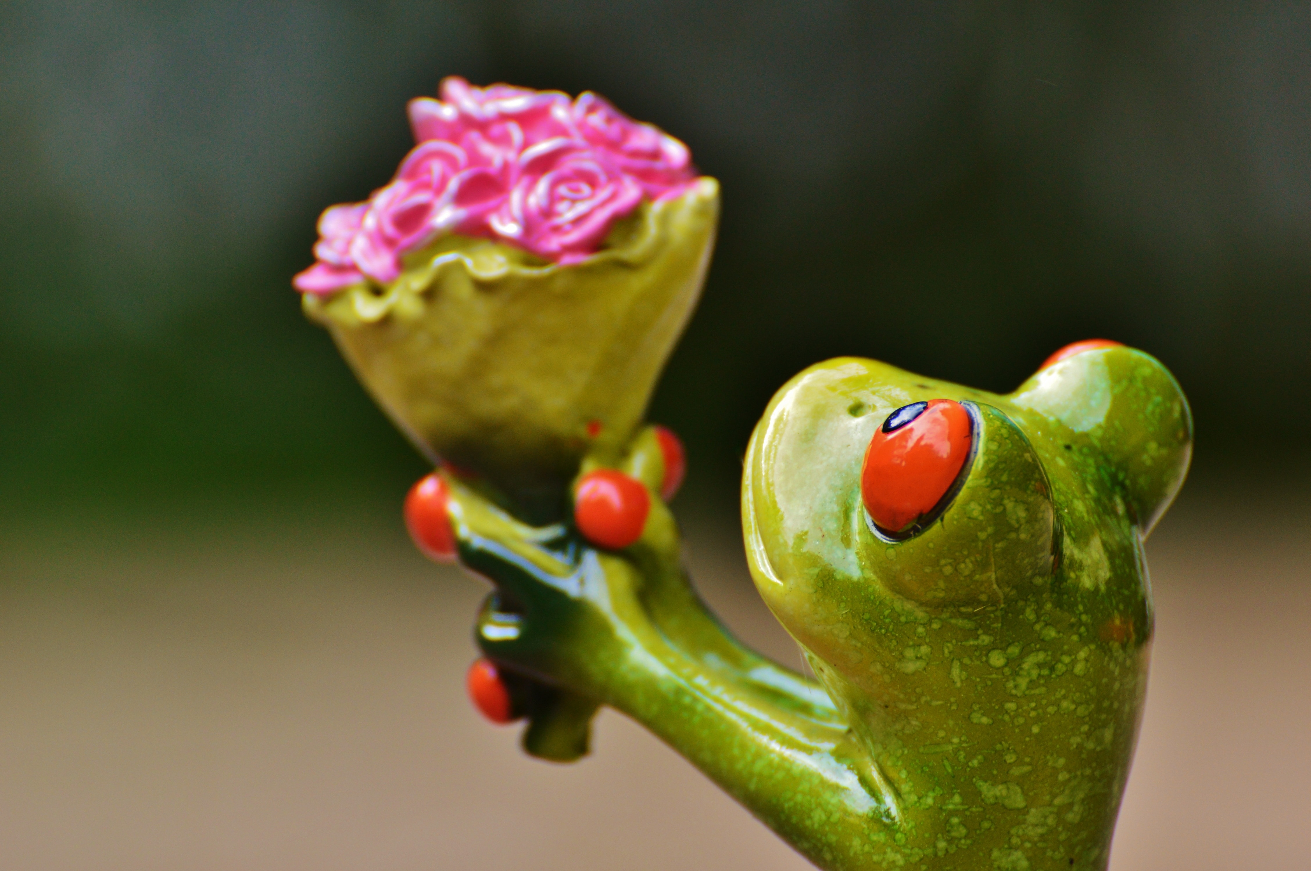 green ceramic frog holding bouquet of flower