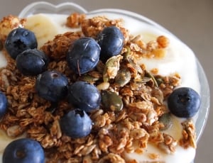cereal and blueberries on white ceramic bowl beside stainless steel ...