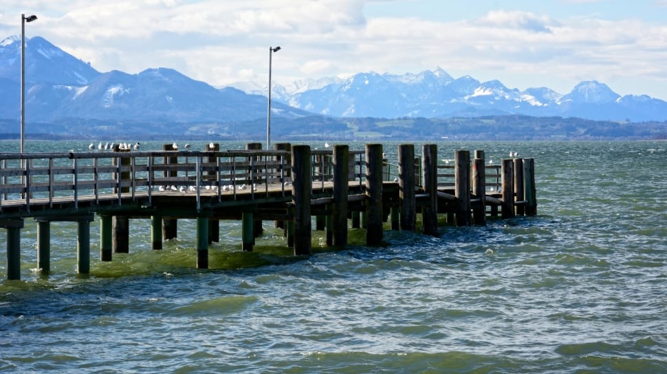aerial photography of black wooden dock surrounded by body of water under nimbus clouds during daytime preview
