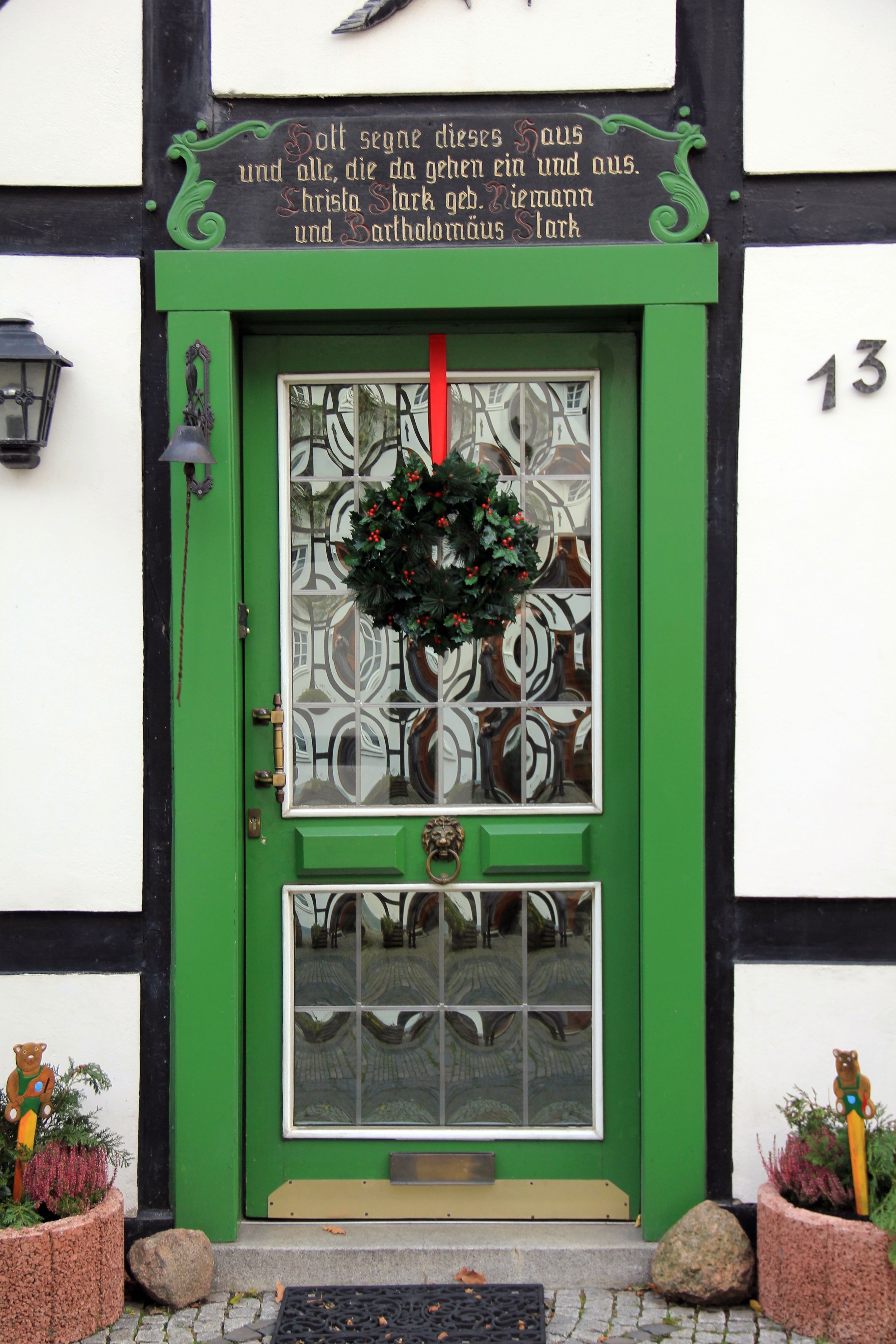 green wooden frame clear glass storm door with mistletoe wreath