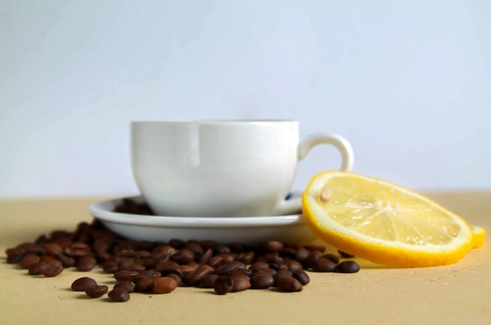 white ceramic teacup with coffee beans and slice lemon preview