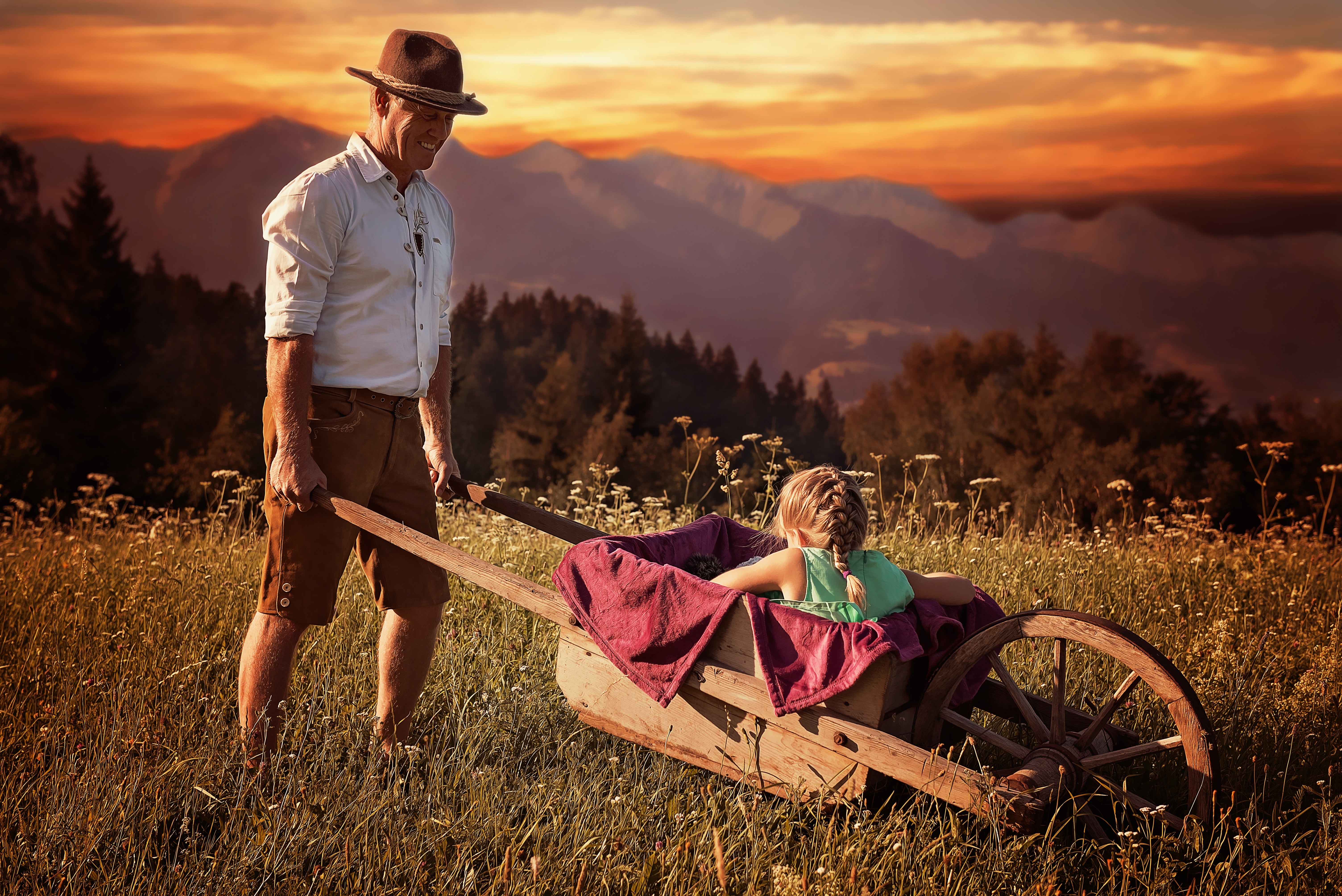 girl riding on brown wooden wheelbarrow carrying by man during sunset