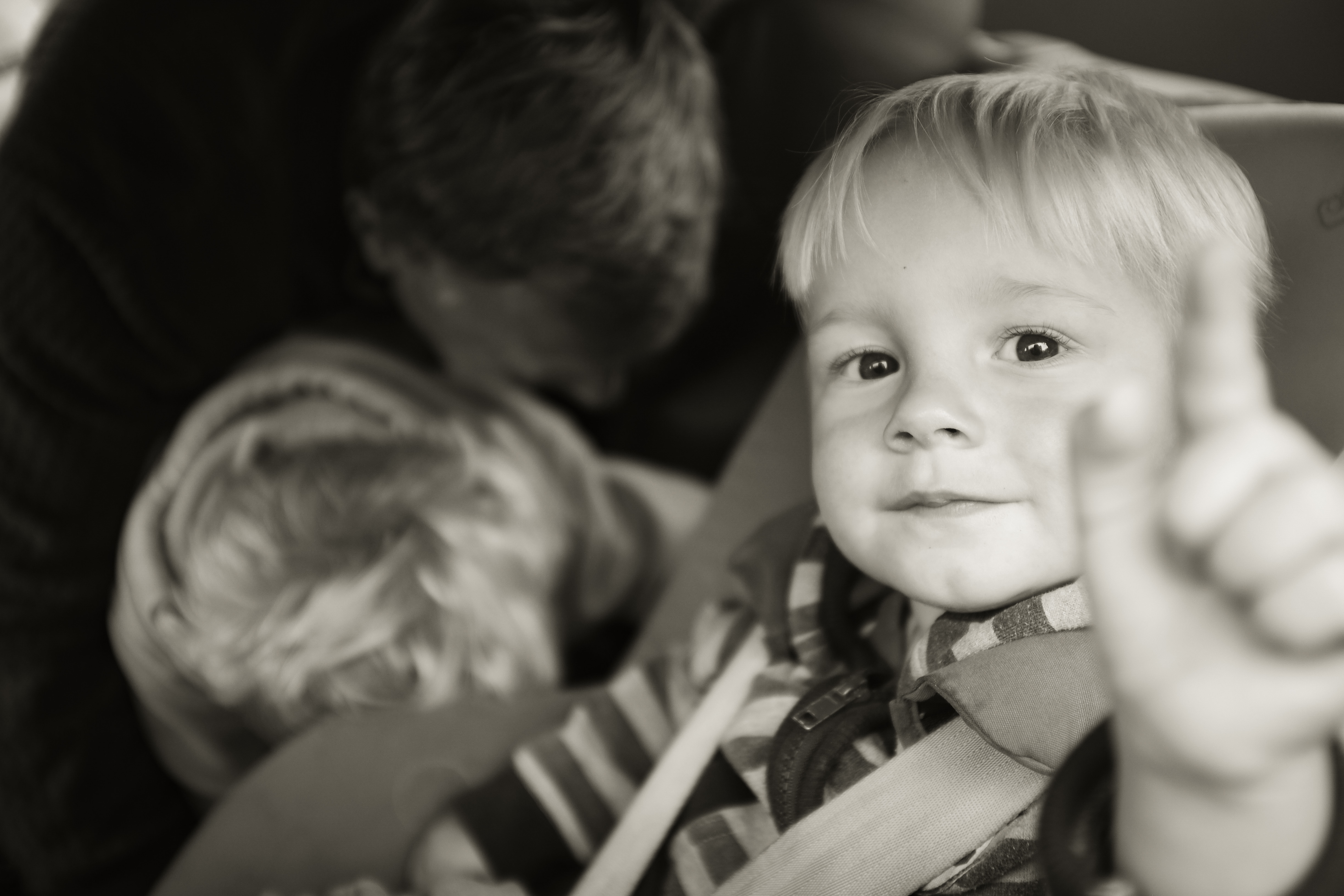 grayscale photo of baby and another boy behind