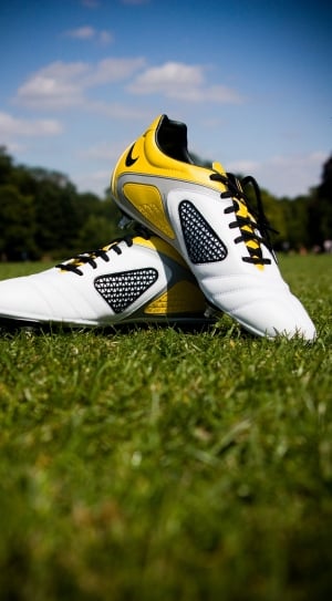 pair of white-and-yellow nike cleats thumbnail
