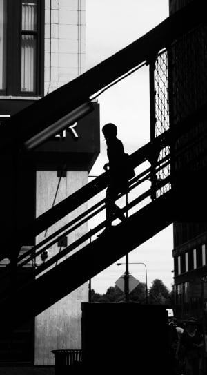 black and white picture of woman walking down the stairs thumbnail