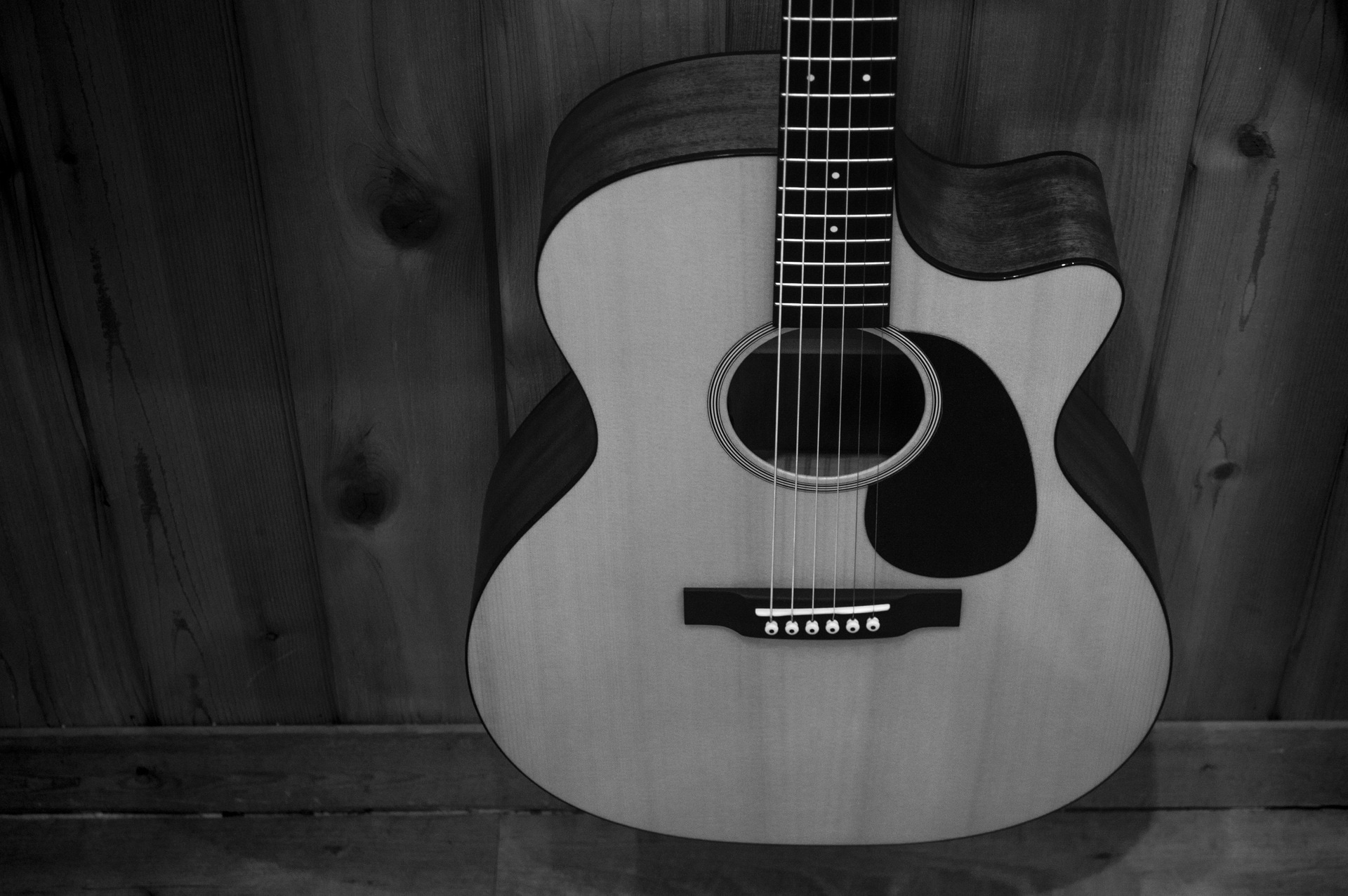 greyscale photo of acoustic guitar