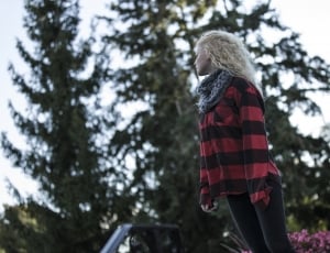 woman in red and black plaid coat standing during daytime thumbnail