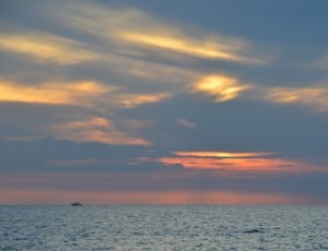 body of water under blue and orange clouds during sunset thumbnail