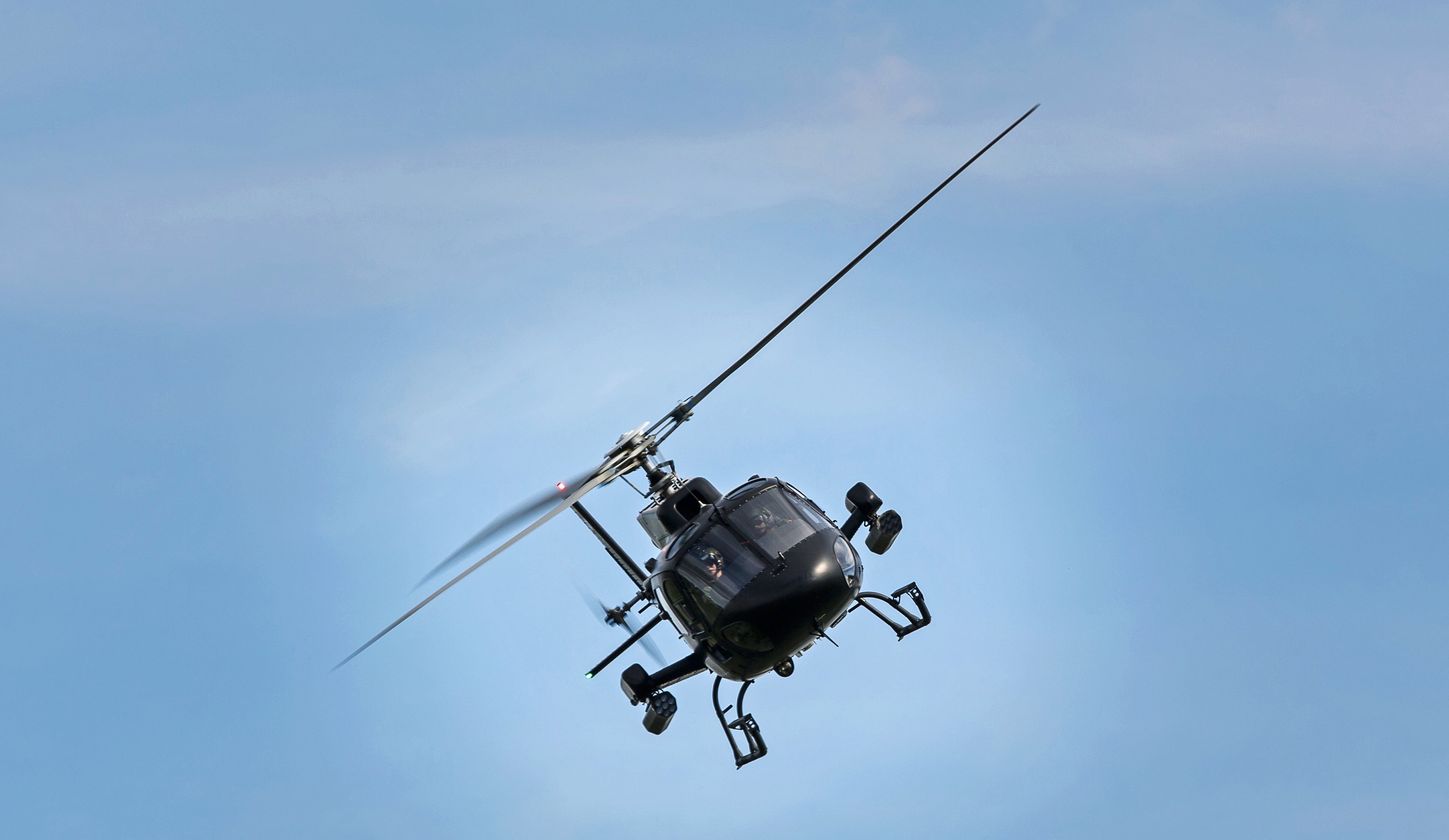 black helicopter under blue sky