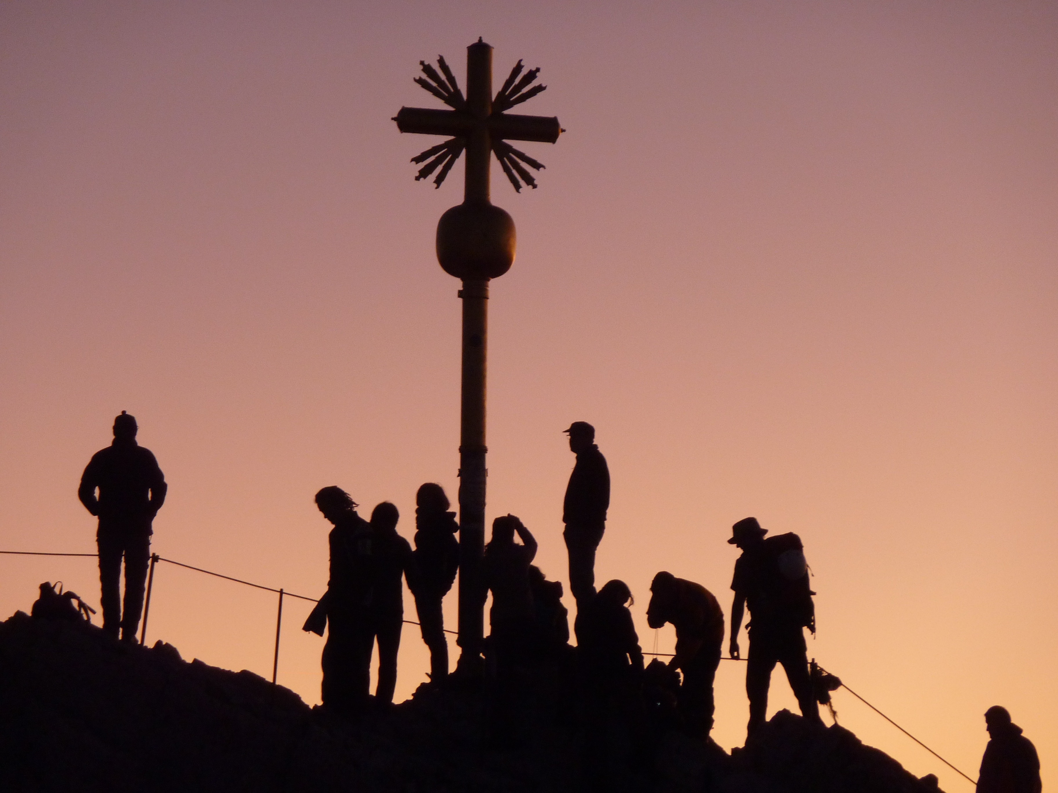 silhouette of people and cross statue
