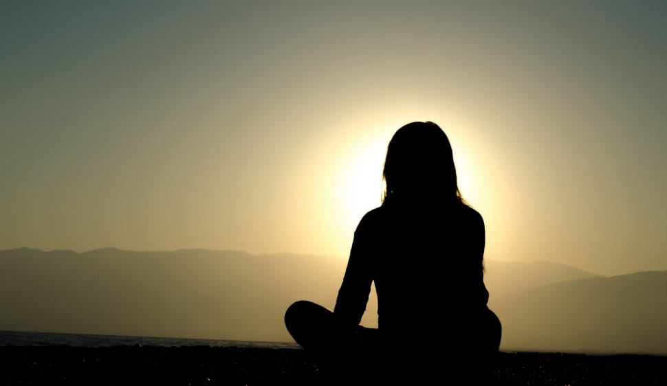 silhouette of woman sitting during golden hour preview