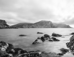 Body of Water and Mountain in Greyscale Photography thumbnail