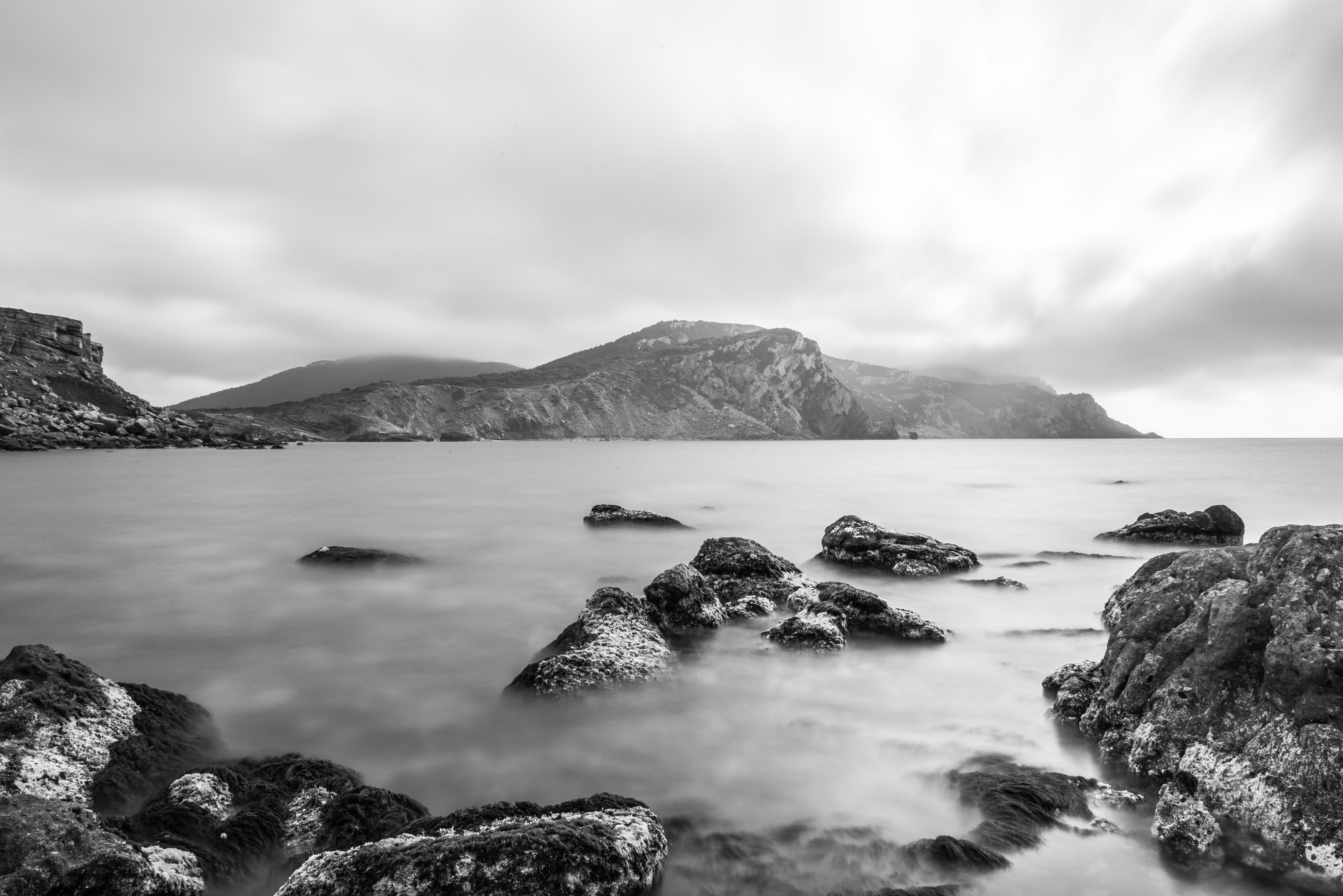 Body of Water and Mountain in Greyscale Photography
