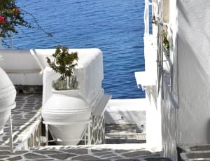 white concrete balcony with vases near ocean during daytime thumbnail