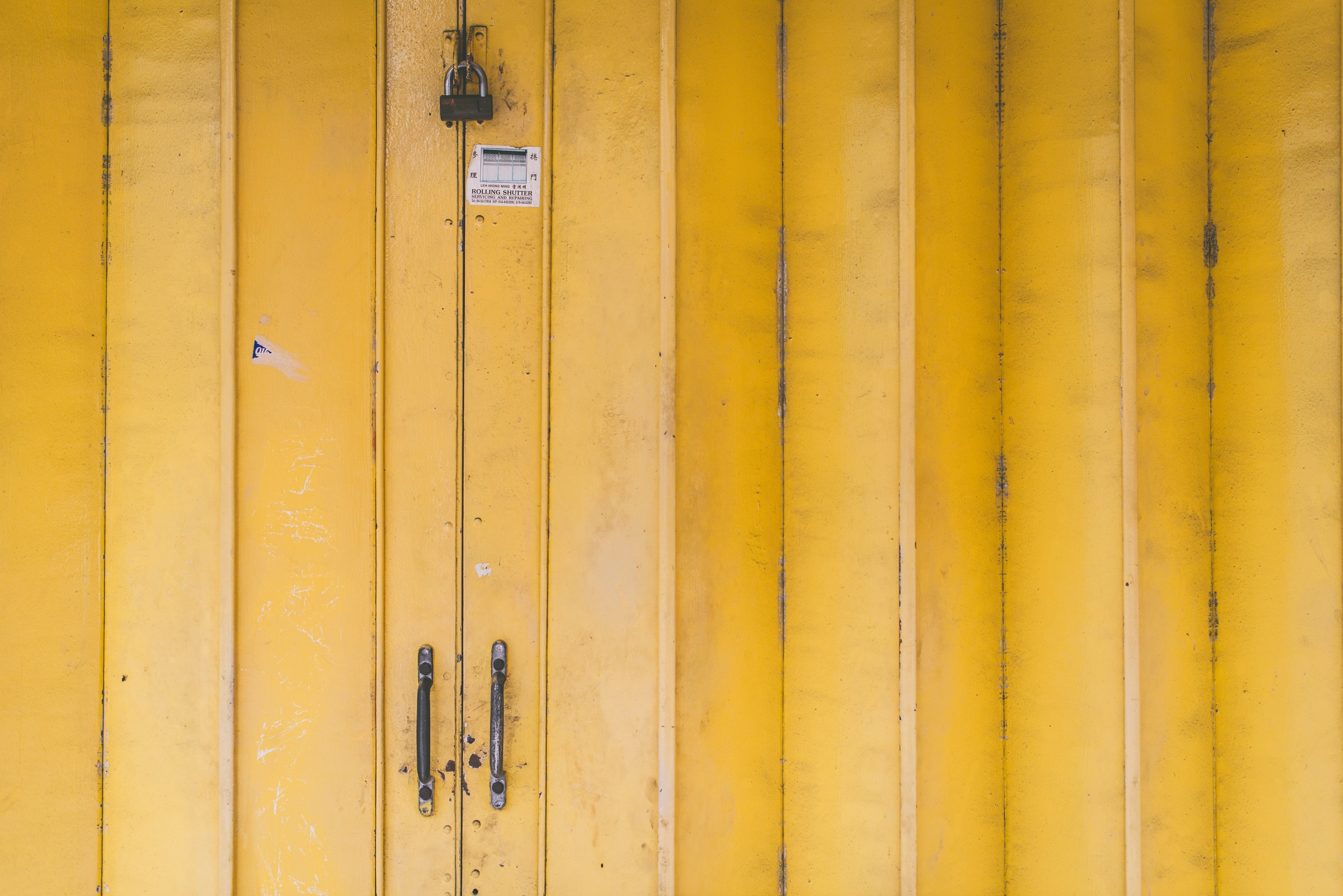 closeup view of yellow door with padlock