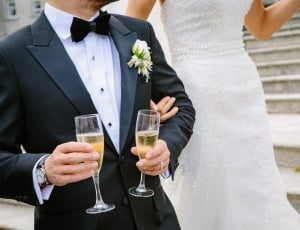 bride beside groom carrying glasses of champagne thumbnail